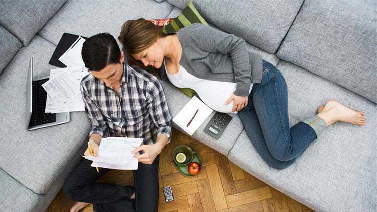 Man and woman on couch looking through contracts.